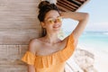 Fascinating young woman with tanned skin posing on wooden background with happy smile. Outdoor shot Royalty Free Stock Photo