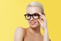 Fashion and Accessories. Model girl isolated over yellow background. Beauty stylish blonde woman posing in glasses