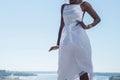 Fashion african black girl in a white dress, model posing on a background of blue sky. Young african american girl model in white Royalty Free Stock Photo