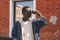 Fashion african man with vintage film camera taking picture on city street Royalty Free Stock Photo