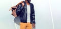 Fashion african man wearing a black biker leather jacket holds a bag Royalty Free Stock Photo