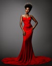 Fashion Afro American Woman in Red Sexy Dress. African Model with Afro Hairstyle in Long Evening Gown over Gray background. Royalty Free Stock Photo