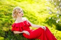 Fashion Art Beauty Portrait. Beautiful Girl in Fantasy Mystical and Magical Spring Garden. Model Woman wearing Long red Royalty Free Stock Photo