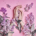 Fashion art hands natural cosmetics women, bright purple lilac flowers in hand with bright contrast makeup, hand care. Creative Royalty Free Stock Photo