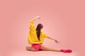 Portrait of young beautiful girl, female ballet dancer training isolated over pink background. Back view Royalty Free Stock Photo