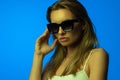 Fashion portrait of beautiful woman face with sunglasses on blue light color Royalty Free Stock Photo