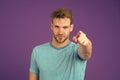 Fashion athlete point finger on violet background. Athletic man in blue tshirt on purple backdrop. Sportsman with beard