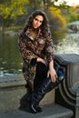 Fashion autumn outdoor photo of beautiful woman posing near the lake in the park. Royalty Free Stock Photo