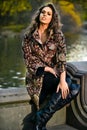 Fashion autumn outdoor photo of beautiful woman posing near the lake in the park. Royalty Free Stock Photo
