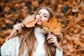 Fashion autumn portrait of stylish woman, posing on park. Curly cute girl in good mood posing in warm day, enjoying good