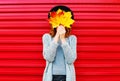 Fashion autumn portrait woman hides her face yellow maple leaves Royalty Free Stock Photo