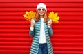 Fashion autumn smiling woman holds a yellow maple leaves in hand Royalty Free Stock Photo