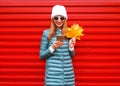 Fashion autumn smiling woman using smartphone holds yellow maple leaves Royalty Free Stock Photo
