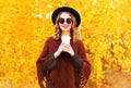 Fashion autumn woman holds coffee cup in black round hat