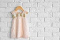 Fashion baby girl dress hanging on white brick wall Royalty Free Stock Photo