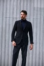 Fashion beard style business handsome male model posing in style clothing blue jacket and trousers on street wall outdoors Royalty Free Stock Photo