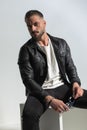 Fashion bearded man in leather jacket with wet hair holding sunglasses Royalty Free Stock Photo