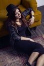 Fashion beautiful middle eastern model with hipster style is posing on carpet and yellow sofa. Royalty Free Stock Photo