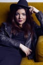 Fashion beautiful middle eastern model with hipster style is posing on carpet and yellow sofa. Royalty Free Stock Photo