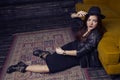 Fashion beautiful middle eastern model with hipster style is posing on carpet and yellow sofa. Royalty Free Stock Photo