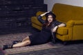 Fashion beautiful middle eastern model with hipster style is posing on carpet and yellow sofa. Royalty Free Stock Photo