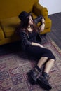 Fashion beautiful middle eastern model with hipster style is posing on carpet and yellow sofa. Royalty Free Stock Photo