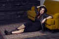 Fashion beautiful middle eastern model with hipster style is posing on carpet and yellow sofa. Royalty Free Stock Photo