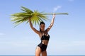 Fashion beautiful woman in bikini with palm branch