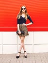 Fashion beautiful woman in leopard skirt sunglasses handbag clutch over red Royalty Free Stock Photo