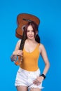 Fashion of a beautiful young asian woman in a pretty yellow vest White shorts hand holding acoustic guitar. A musician smiling and Royalty Free Stock Photo