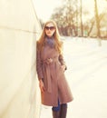 Fashion beautiful young blonde woman wearing coat jacket and sunglasses in winter city Royalty Free Stock Photo