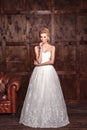 Fashion beauty bridal shooting. Beautiful fashion bride in wedding dress posing in front of woody background.