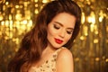 Fashion Beauty Girl Portrait Isolated on golden Christmas glittering bokeh lights background. Glamour Makeup. Long wavy Hair style Royalty Free Stock Photo