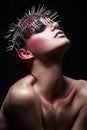 Fashion beauty model with metallic headwear and shiny silver red makeup and blue eyes and red eyebrows on black background Royalty Free Stock Photo