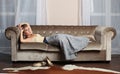 Fashion beauty portrait of nice brunette woman wearing blue dress posing on sofa indoor Royalty Free Stock Photo