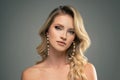 Fashion beauty portrait of young caucasian woman with pearls jewelry and elegant hairstyle. Blonde girl with long wavy hair Royalty Free Stock Photo