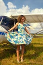 Fashion beautyful woman in pinup style dress nearby ultralight plane Royalty Free Stock Photo