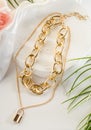 Fashion bijouterie - double gold chain with a lock on a white stand Royalty Free Stock Photo