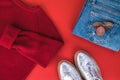 Woman fall/winter clothes laying on red background. Jeans, yellow knitted jumper, silver flat shoes. Royalty Free Stock Photo