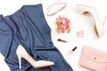 Fashion blogger workspace flat lay with pumps, blue top, cosmetics, purse and flowers.