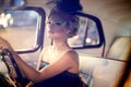 Fashion blond model in retro style in old car Royalty Free Stock Photo