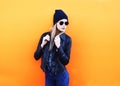 Fashion blonde woman in rock black style posing over orange Royalty Free Stock Photo