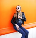 Fashion blonde woman wearing a rock black style over orange Royalty Free Stock Photo