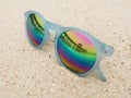 Fashion blue frame sunglasses on sandy sea beach with mirror