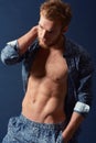 Fashion, body and muscle with a man in studio on a blue background wearing an open unbuttoned shirt. Fitness, chest and Royalty Free Stock Photo