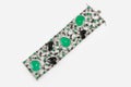 Fashion bracelet with diamonds and emerald natural gem stones on gray background. Green and black precious stones in luxury