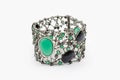 Fashion bracelet with diamonds and emerald natural gem stones on gray background. Green and black precious stones in luxury