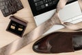 Fashion and business, notebook, shoes, cufflinks, tie on a wooden table as background.