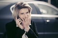 Fashion business woman calling on cell phone next to her car Royalty Free Stock Photo