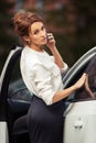 Fashion business woman calling on mobile phone beside a car Royalty Free Stock Photo